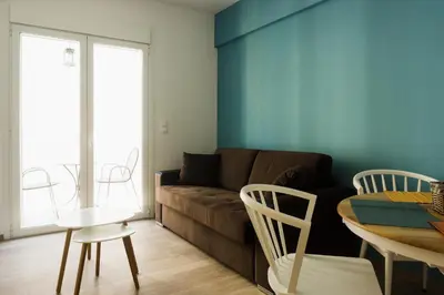 a living room with a couch and a table and chairs at Comfort Zone Apartment in the heart of Athens in Athens