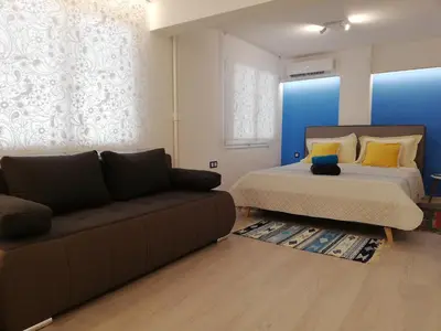 a bedroom with a bed and a couch at ATHENS *BLUE GRAND SUITE *DI GIORGIO CENTRAL APARTMENT in Athens