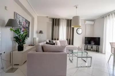 a living room with a couch and a tv at Luxury Apt Near The Airport in Spáta