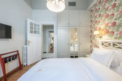a bedroom with a white bed and a floral wall at The Rare Luxury Gem in Kolonaki Sq - near Syntagma in Athens