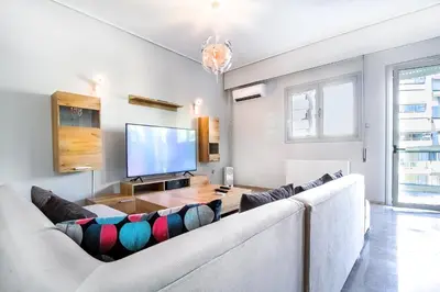 a living room with a large couch and a flat screen tv at Luxurious 2bedroom flat near Athens center in Athens