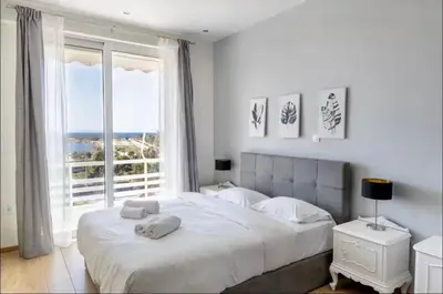 a bedroom with a large bed with a large window at Glyfada Panoramic Seaview Penthouse in Athens