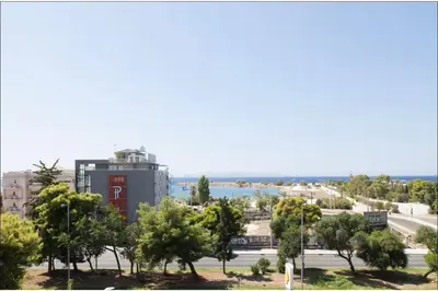 a view of a city with trees and a building at Glyfada Panoramic Seaview Penthouse in Athens