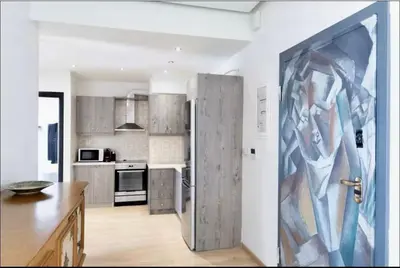 a kitchen with a large painting on the wall at Glyfada Panoramic Seaview Penthouse in Athens