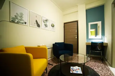 a living room with a yellow couch and a glass table at El Pacífico in Athens