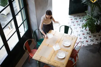 a woman is standing near a table with plates on it at City Circus Athens in Athens