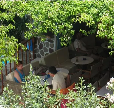 a group of people sitting at tables in a restaurant at Costantonia Holiday Apartments in Agia Marina Aegina