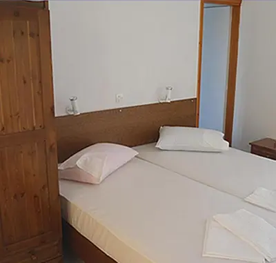 a pair of beds in a room with at Costantonia Holiday Apartments in Agia Marina Aegina