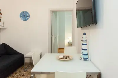 a living room with a table and a clock on the wall at Lovely 2 bedroom apt in Metaxourgio Center in Athens