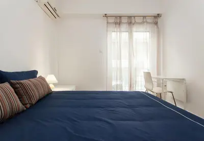 a bedroom with a blue bed and a window at Lovely 2 bedroom apt in Metaxourgio Center in Athens