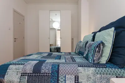 a bedroom with a bed with a quilt on it at Lovely 2 bedroom apt in Metaxourgio Center in Athens