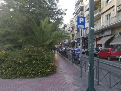 a street with a parking sign on a sidewalk at Comfortable & Convenient Living in Athens in Athens