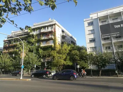 a tall building with cars parked in front of it at Comfortable & Convenient Living in Athens in Athens