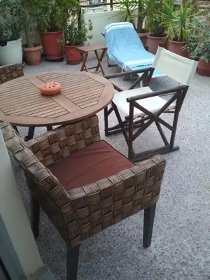 a group of chairs and a wooden table and chairs at George's Apartment in Athens