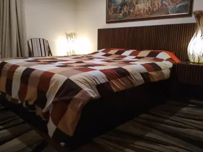 a bed with a checkered blanket in a bedroom at George's Apartment in Athens