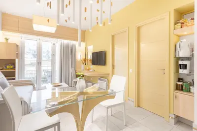 a dining room with a glass table and white chairs at Acropolis Suites - Where else in Athens? in Athens
