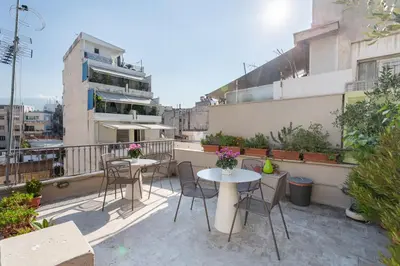 a patio with tables and chairs on a balcony at Acropolis Suites - Where else in Athens? in Athens
