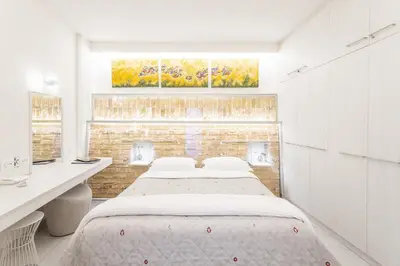 a bedroom with a bed and a desk and a window at Acropolis Suites - Where else in Athens? in Athens