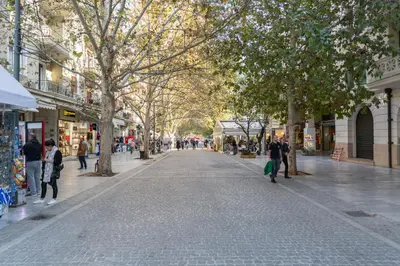 a city street with people walking down a street at Acropolis Suites - Where else in Athens? in Athens