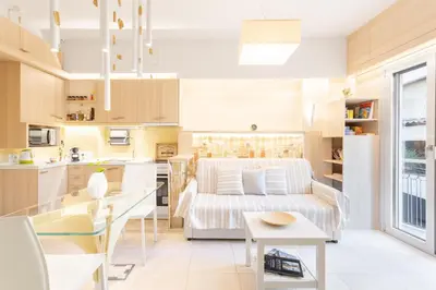 a living room and kitchen with a couch and a table at Acropolis Suites - Where else in Athens? in Athens