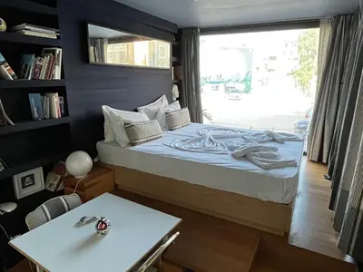 a bedroom with a bed and a table and a window at So Athens - Studios and Apartments in Athens