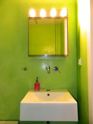 a green bathroom with a sink and a mirror at So Athens - Studios and Apartments in Athens