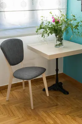 a chair sitting next to a table with a vase of flowers at Neratzia Rooms in Athens