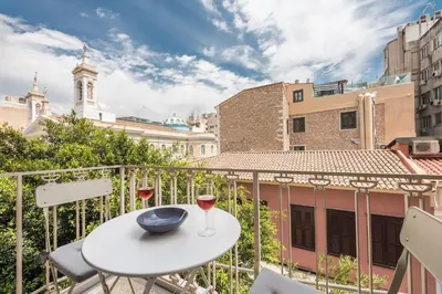 a balcony with a table and a glass of wine at Let me Athens you! in Athens