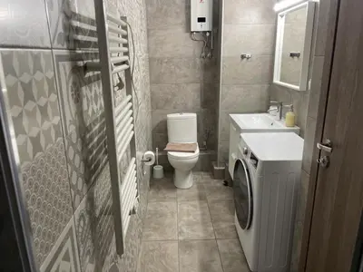 a bathroom with a toilet and a sink and a washing machine at Let me Athens you! in Athens