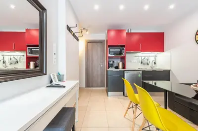 a kitchen with red and white cabinets and yellow chairs at Let me Athens you! in Athens