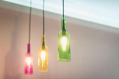 four glass bottles hanging from a ceiling with lights at Let me Athens you! #2 in Athens