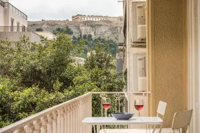 a balcony with a table and two glasses of wine at Let me Athens you! #2 in Athens