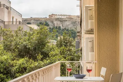a balcony with a table and two glasses of wine at Let me Athens you! #2 in Athens
