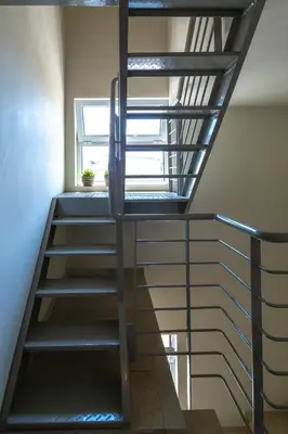 a metal spiral staircase in a room with a window at Solon - Deluxe City Center Apartment in Athens