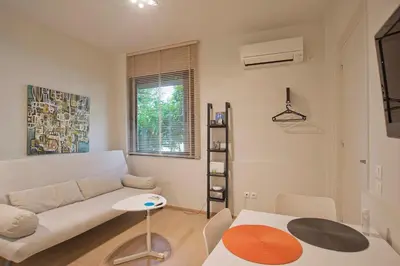a living room with a white couch and a table at Cozy and modern studio next to the sea in Athens