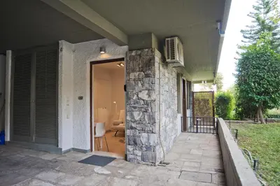 a front door of a house with a stone pillar at Cozy and modern studio next to the sea in Athens