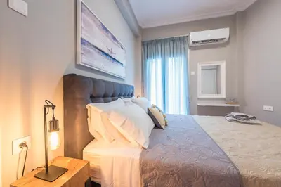 a bedroom with a large bed with a blue headboard at Elegant living at the heart of Athens in Athens