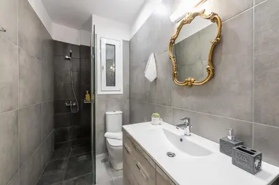 a bathroom with a sink and a mirror and a toilet at Elegant living at the heart of Athens in Athens