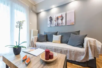 a living room with a couch and a table at Elegant living at the heart of Athens in Athens