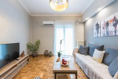 a living room with a couch and a tv at Elegant living at the heart of Athens in Athens