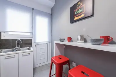 a kitchen with a red stool next to a sink at Elegant living at the heart of Athens in Athens