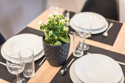 a table with white plates and a plant on it at Elegant living at the heart of Athens in Athens
