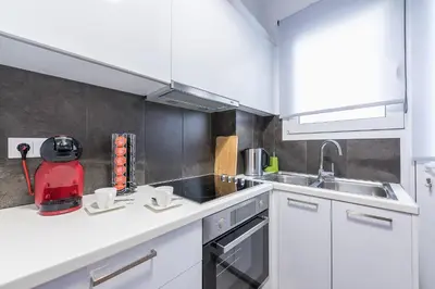 a kitchen with white cabinets and a red appliance at Elegant living at the heart of Athens in Athens