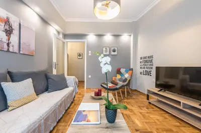 a living room with a couch and a flat screen tv at Elegant living at the heart of Athens in Athens