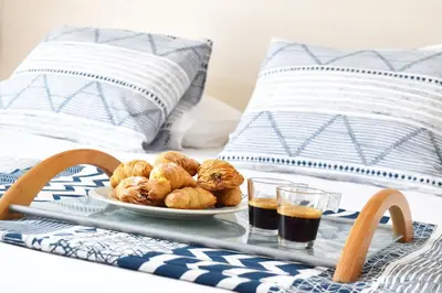 a tray with a plate of pastries on a bed at Poseidon by Heloni Apartments in Piraeus