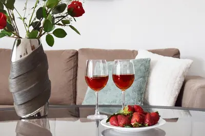 two glasses of wine and a plate of strawberries on a table at Poseidon by Heloni Apartments in Piraeus