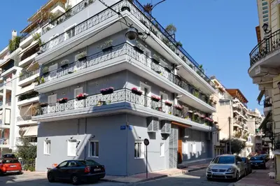 a white building with balconies on a city street at Hercules Residence in Athens