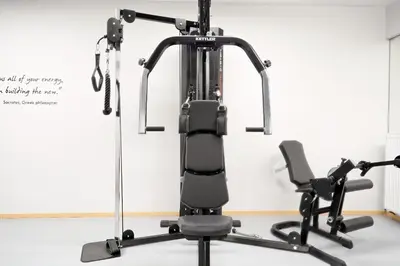 an exercise machine in a room with a chair at Hercules Residence in Athens