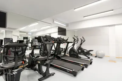 a gym with several tread machines in a room at Hercules Residence in Athens