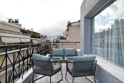 a balcony with two chairs and a table at Hercules Residence in Athens